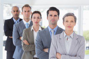 Business people standing in a row arms crossed in the office